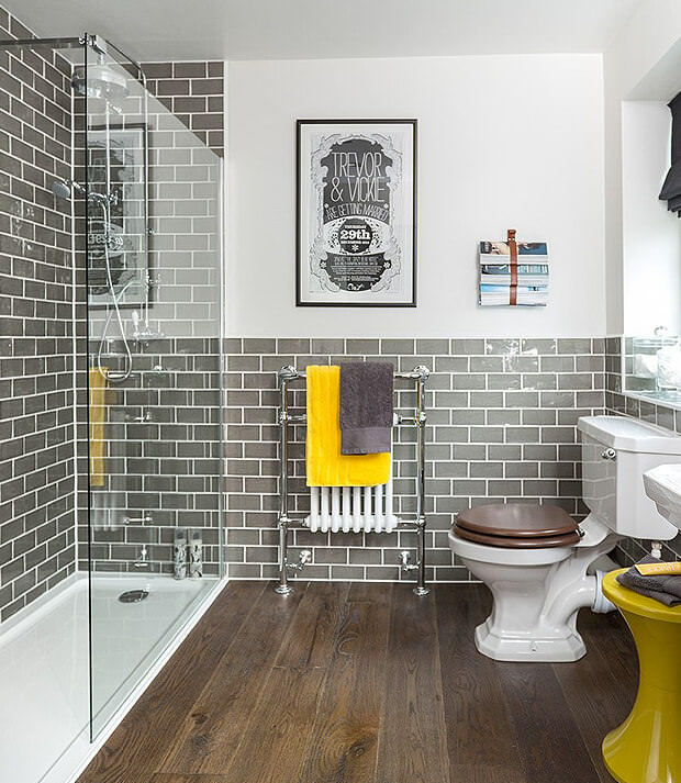 Grey Bathroom With Yellow Towel and Stool